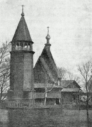 Церковь Преображения и колокольня огорожены частоколом с двумя воротами. фотография